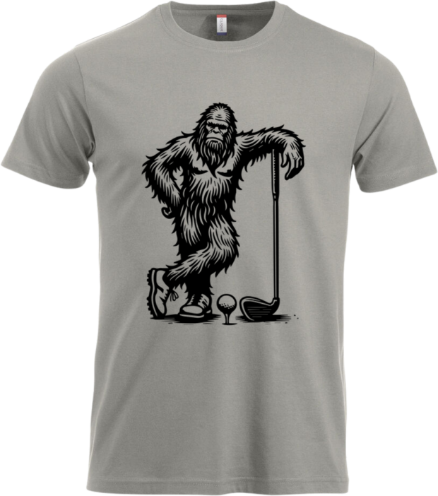 Klassisk t-shirt i lysegrå med tegnet motiv af Bigfoot med golfkølle og golfbold – perfekt som gave til golfspilleren med humor.