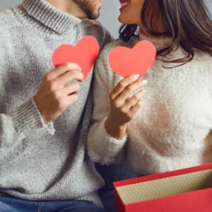 Par holder røde hjerter som en del af en valentinsdag gave.