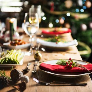 Festligt julebord med elegant opdækning, røde servietter og dekorationer – perfekt inspiration til julefrokost og tøjvalg, der matcher den hyggelige julestemning.